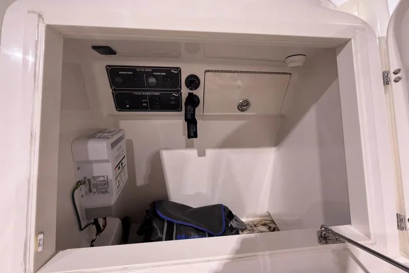 Slide: The Image of Electrical panel inside 2025 SeaVee 270Z boat compartment, featuring switches and storage. - 41