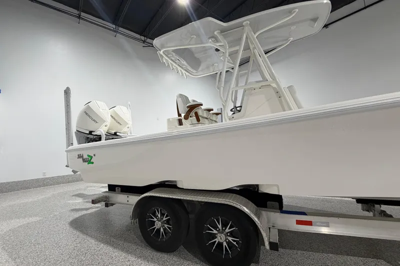 Slide: The Image of 2025 SeaVee 270Z boat on trailer, featuring dual Mercury engines in a showroom. - 7