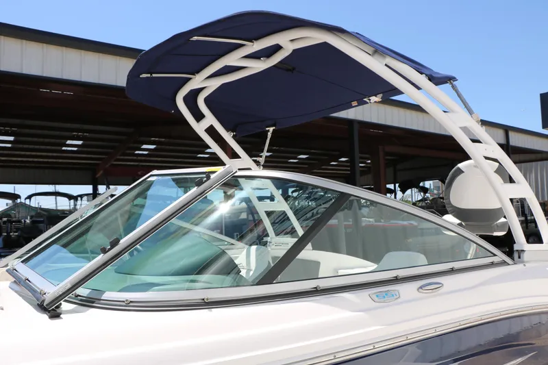 Slide: The Image of 2023 Chaparral 21 SSi Ski & Fish boat with blue canopy in marina setting. - 14