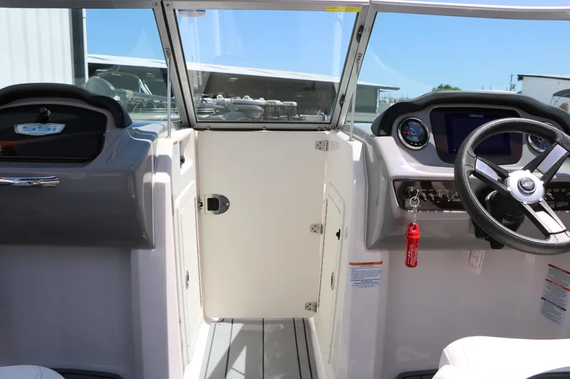 Slide: The Image of 2023 Chaparral 21 SSi Ski & Fish boat cockpit with steering wheel and dashboard controls. - 41