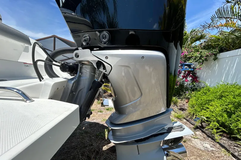 Slide: The Image of Close-up of a 2020 Cobalt 23SC boat engine, surrounded by lush greenery. - 10