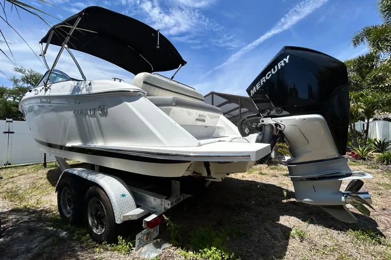 Slide: The Image of 2020 Cobalt 23SC boat with Mercury engine on trailer, under sunny sky. - 12