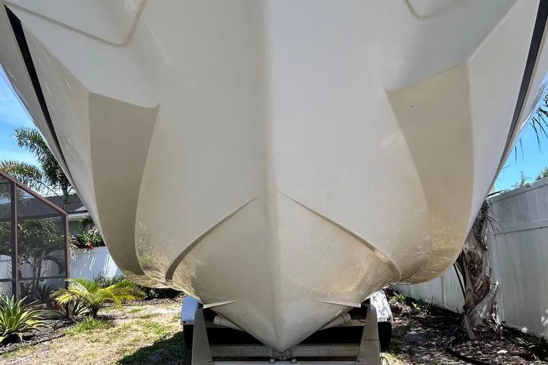 Slide: The Image of 2020 Cobalt 23SC boat on trailer, parked in a sunny backyard with tropical plants. - 17