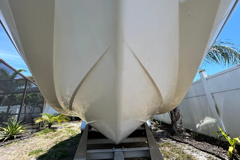 Slide: The Image of 2020 Cobalt 23SC boat hull on trailer, surrounded by tropical plants and clear sky. - 18
