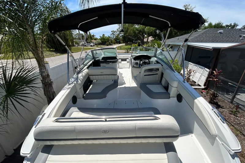 Slide: The Image of 2020 Cobalt 23SC boat with spacious seating and canopy in a residential setting. - 19