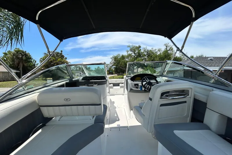 Slide: The Image of 2020 Cobalt 23SC boat interior with seating and steering wheel under a canopy. - 25