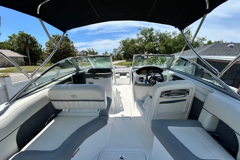 Slide: The Image of 2020 Cobalt 23SC boat interior with sleek seating and modern dashboard under a sunny sky. - 26