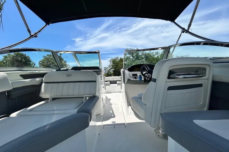Slide: The Image of 2020 Cobalt 23SC boat interior with seating and steering wheel under a clear blue sky. - 30