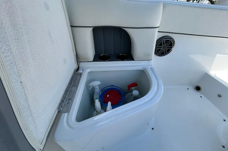 Slide: The Image of Storage compartment on a 2020 Cobalt 23SC boat with cleaning supplies inside. - 32