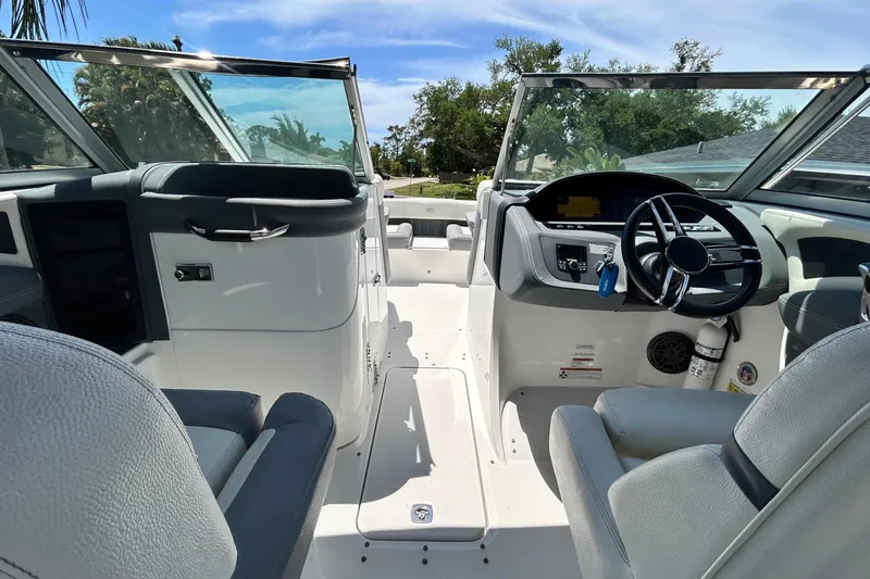 Slide: The Image of Interior view of a 2020 Cobalt 23SC boat, featuring steering wheel and seating. - 34