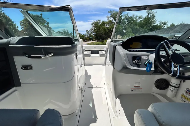 Slide: The Image of 2020 Cobalt 23SC boat interior with steering wheel and dashboard under clear blue sky. - 35