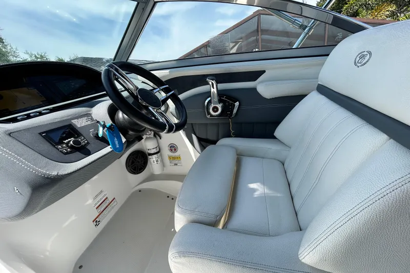 Slide: The Image of 2020 Cobalt 23SC boat interior with steering wheel and white seating. - 36