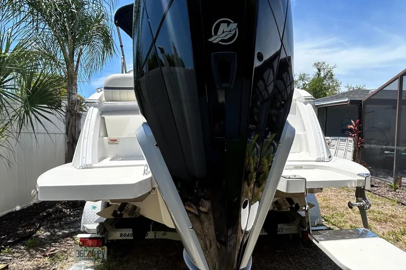 Slide: The Image of 2020 Cobalt 23SC boat with outboard motor, parked outdoors near palm trees. - 4