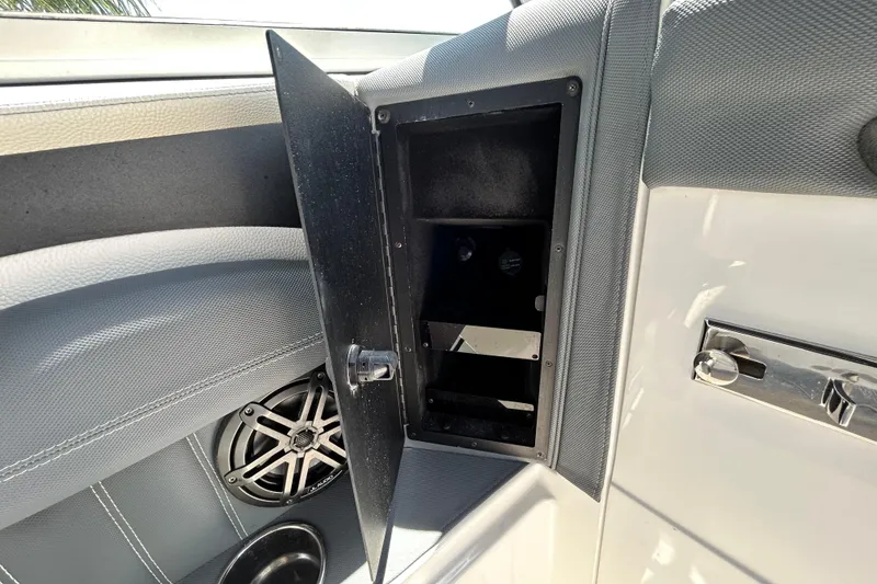 Slide: The Image of Open storage compartment in 2020 Cobalt 23SC boat interior, featuring speaker and sleek design. - 55