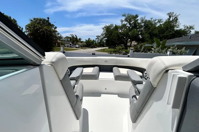 Slide: The Image of 2020 Cobalt 23SC boat interior with seating, under a clear blue sky. - 60