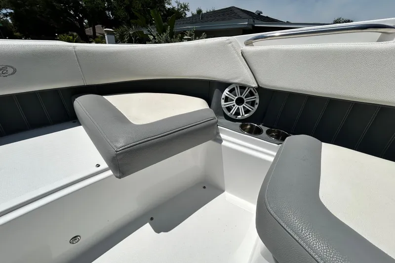 Slide: The Image of Interior of a 2020 Cobalt 23SC boat featuring cushioned seating and built-in speakers. - 64