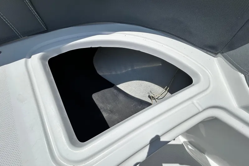 Slide: The Image of Open storage compartment on a 2020 Cobalt 23SC boat, featuring a sleek white interior. - 69
