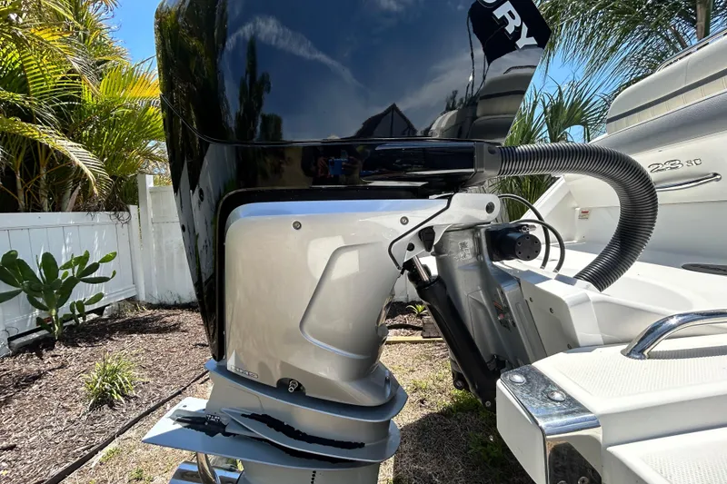 Slide: The Image of 2020 Cobalt 23SC boat with Mercury outboard motor in a sunny garden setting. - 7