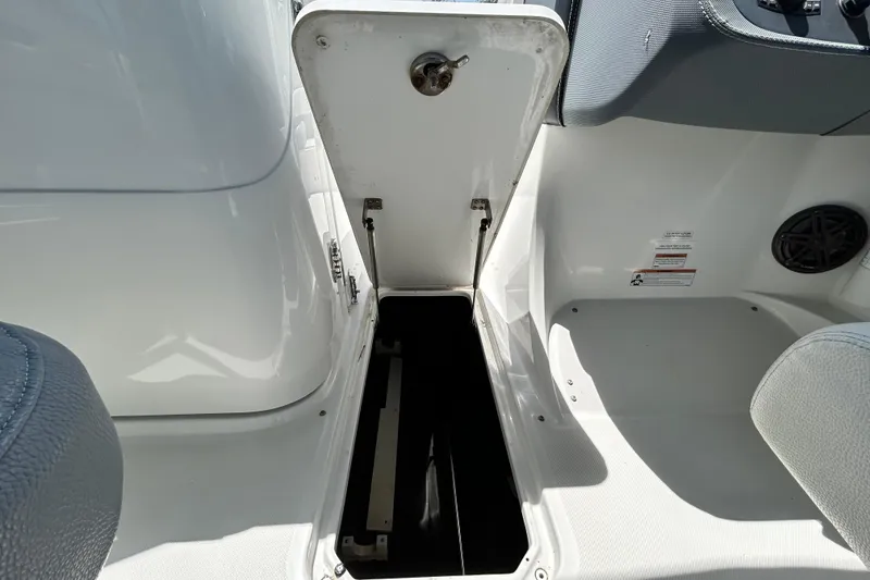 Slide: The Image of Open storage compartment on a 2020 Cobalt 23SC boat interior. - 70