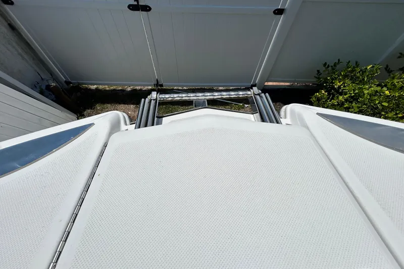 Slide: The Image of 2020 Cobalt 23SC boat deck with ladder, near white fence and greenery. - 75