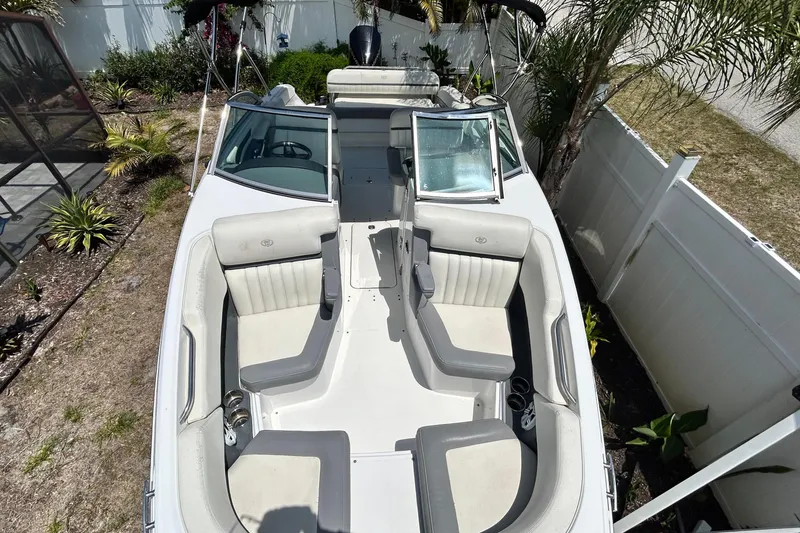 Slide: The Image of 2020 Cobalt 23SC boat with spacious seating, parked outdoors near palm trees. - 76