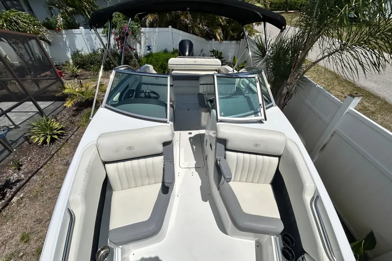 Slide: The Image of 2020 Cobalt 23SC boat with spacious seating, parked in a tropical garden setting. - 77