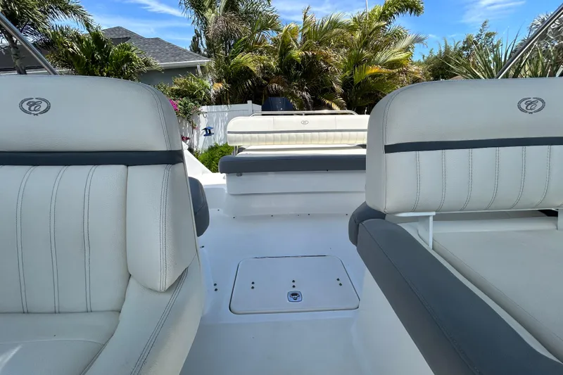 Slide: The Image of 2020 Cobalt 23SC boat interior with white leather seats and lush greenery background. - 86