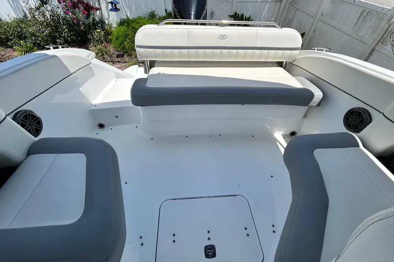 Slide: The Image of 2020 Cobalt 23SC boat interior with white and gray seating, outdoor setting. - 88