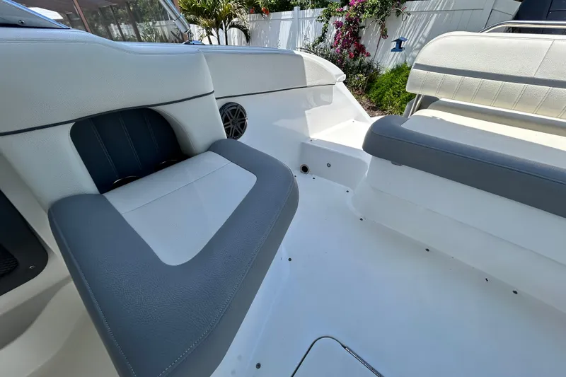 Slide: The Image of 2020 Cobalt 23SC boat interior with white and gray seating, outdoor setting. - 92