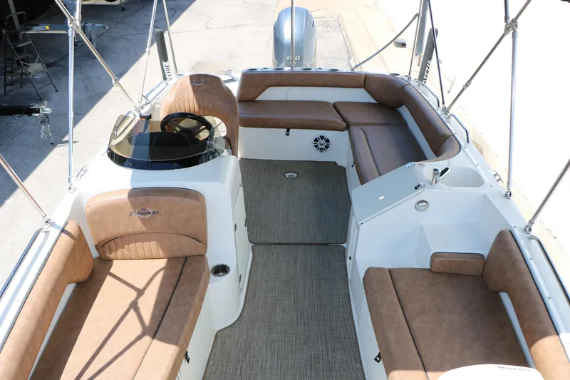 Slide: The Image of 2020 Stingray 192 SC boat interior with tan seating and steering console. - 21