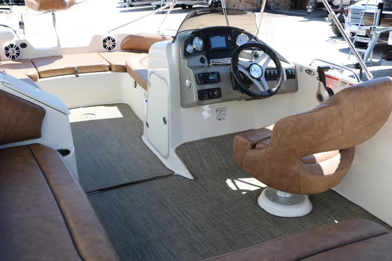 Slide: The Image of 2020 Stingray 192 SC boat interior with brown seating and modern dashboard. - 29