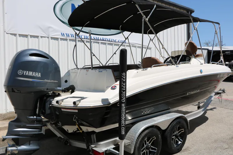 Slide: The Image of 2020 Stingray 192 SC boat with Yamaha outboard motor on trailer, parked outdoors. - 3