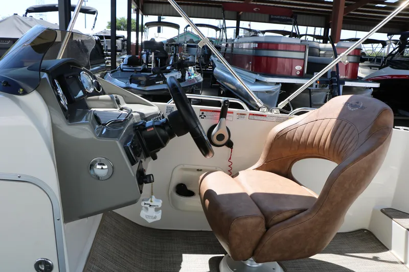 Slide: The Image of 2020 Stingray 192 SC boat interior with steering wheel and brown captain's chair. - 40