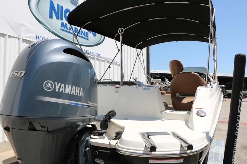 Slide: The Image of 2020 Stingray 192 SC boat with Yamaha 150 engine, docked at a marina. - 6