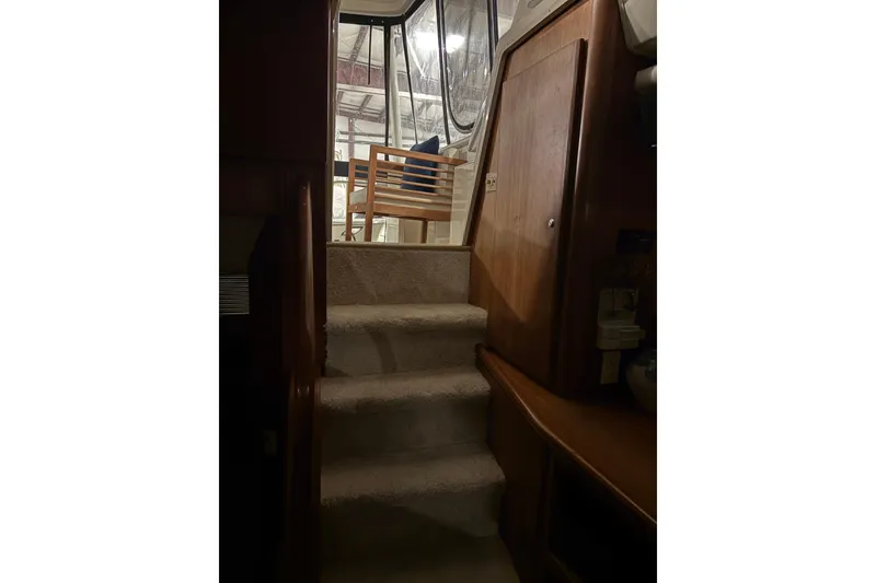 Slide: The Image of Interior stairs of 2003 Silverton 43 Motor Yacht, leading to upper deck with wooden railing. - 18