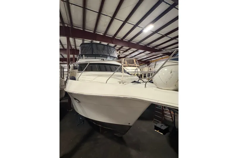 Slide: The Image of 2003 Silverton 43 Motor Yacht in indoor storage, showcasing sleek design and spacious deck. - 2