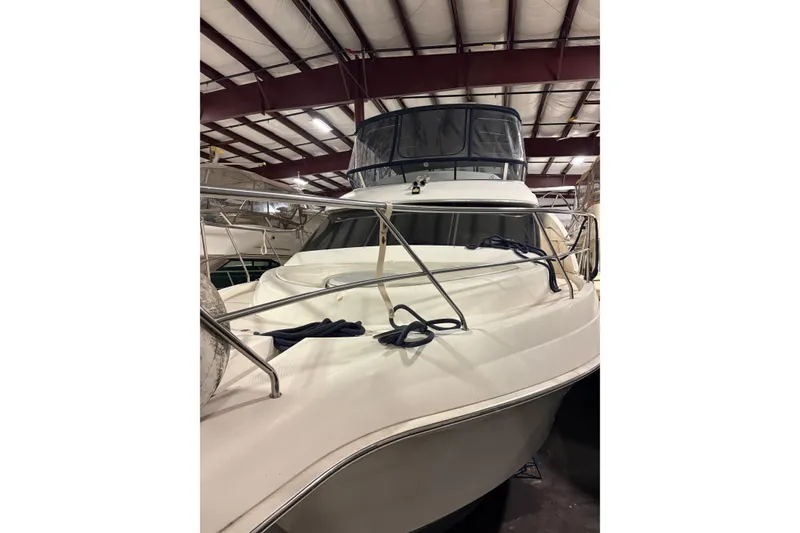 Slide: The Image of 2003 Silverton 43 Motor Yacht in indoor storage, showcasing sleek design and sturdy railings. - 3