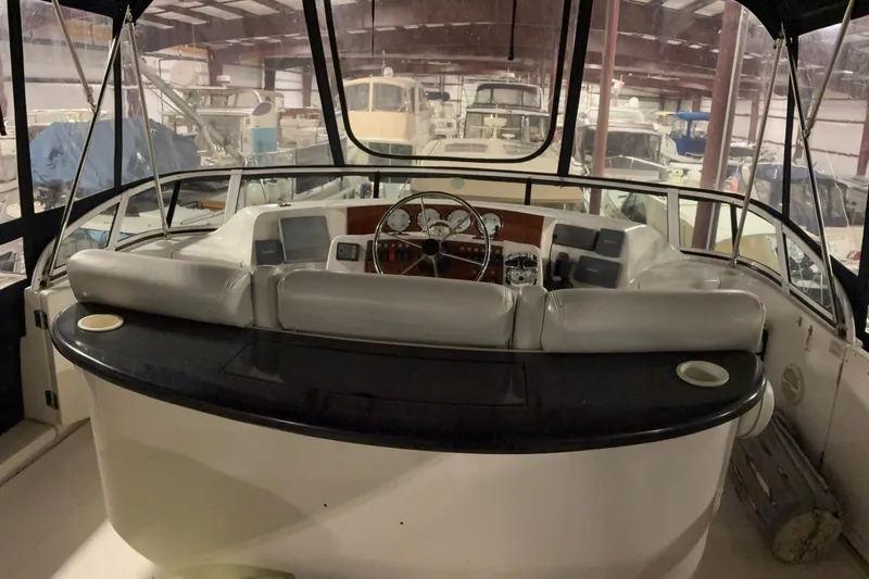 Slide: The Image of 2003 Silverton 43 Motor Yacht helm with leather seating in a boat storage facility. - 9