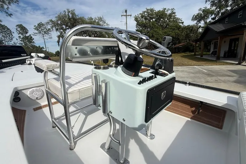 Slide: The Image of 2017 East Cape Vantage boat console with steering wheel and seating, outdoors. - 11