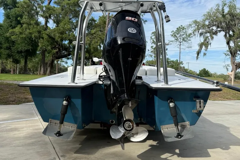 Slide: The Image of 2017 East Cape Vantage boat with outboard motor, parked on concrete, surrounded by trees. - 6