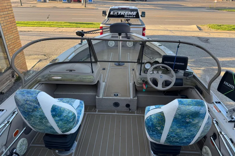 Slide: The Image of 2003 Crestliner 202 Tournament boat interior with steering wheel, seats, and Humminbird electronics. - 14