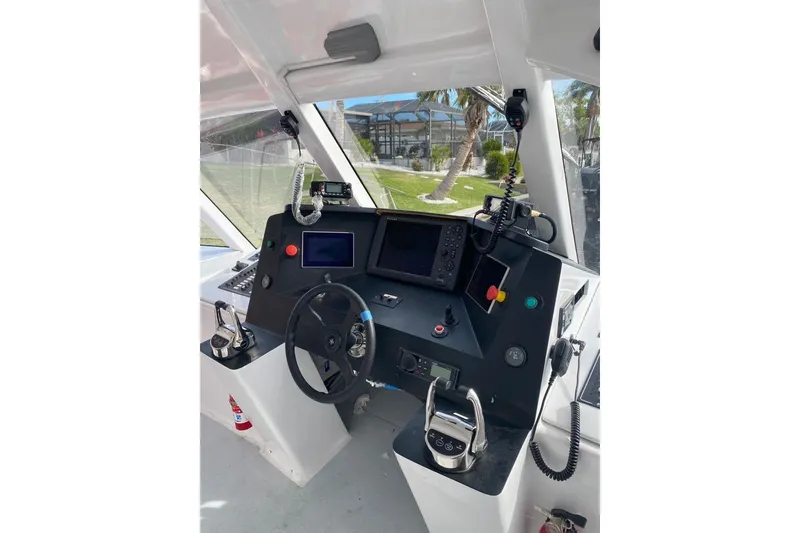 Slide: The Image of Cockpit of a 2003 Gold Coast fast ferry, featuring steering wheel and control panel. - 12