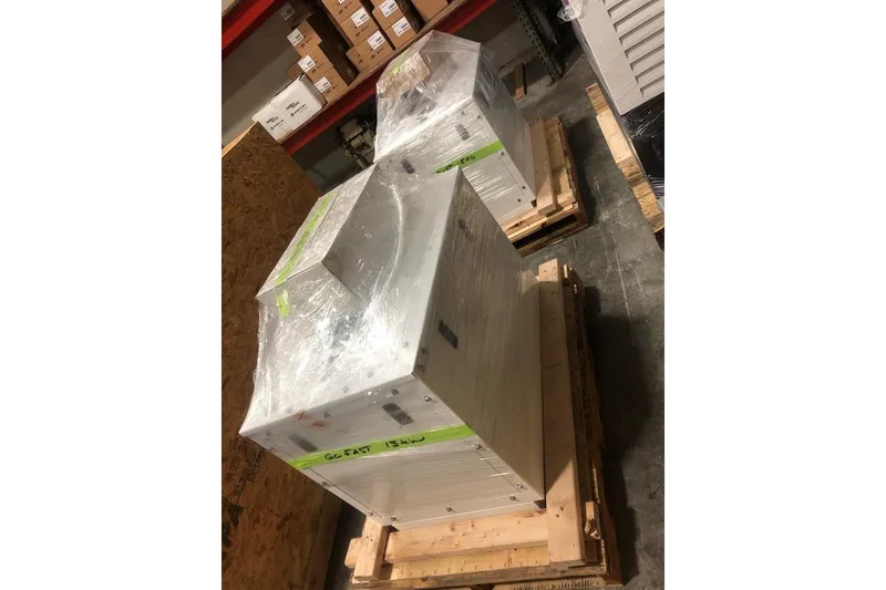 Slide: The Image of Pallets with wrapped equipment labeled "GC FAST 15KW" in a warehouse setting. - 27