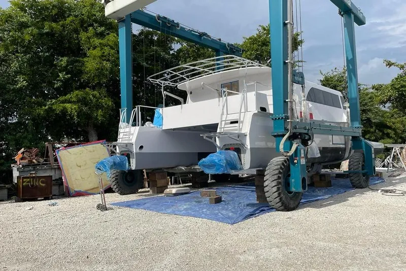 Slide: The Image of A 2003 Gold Coast fast ferry under maintenance on a lift, surrounded by trees. - 7