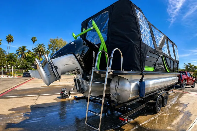 Slide: The Image of 2023 South Bay 525UL AR pontoon boat on trailer, featuring a Mercury outboard motor. - 13