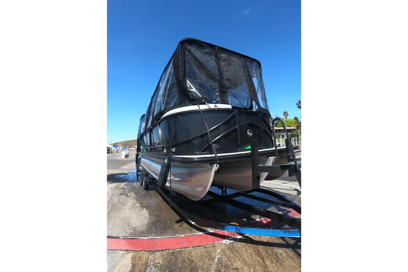 Slide: The Image of 2023 South Bay 525UL AR pontoon boat with protective cover on trailer. - 14