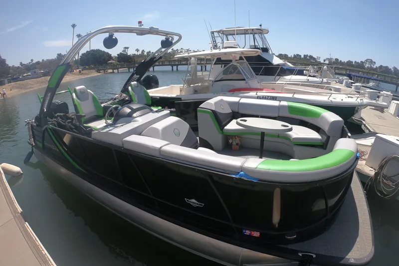 Slide: The Image of 2023 South Bay 525UL AR pontoon boat docked, featuring sleek design and green accents. - 15
