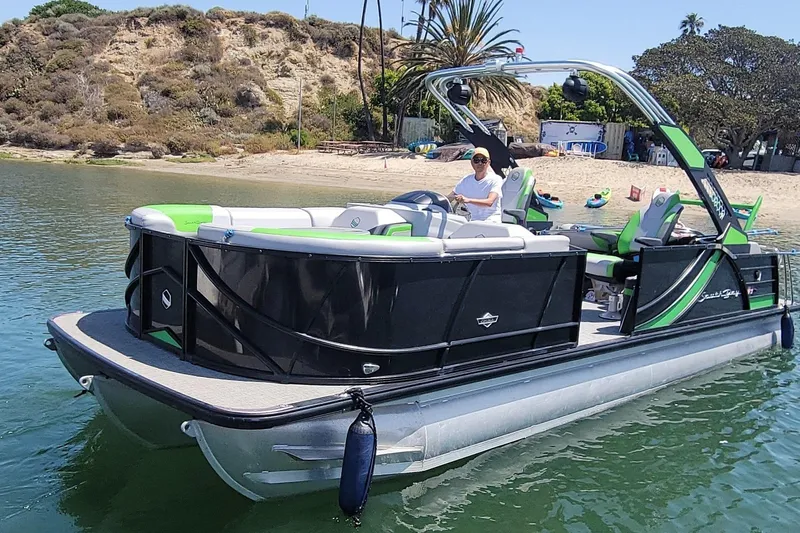 Slide: The Image of 2023 South Bay 525UL AR pontoon boat on water near a sandy beach. - 19