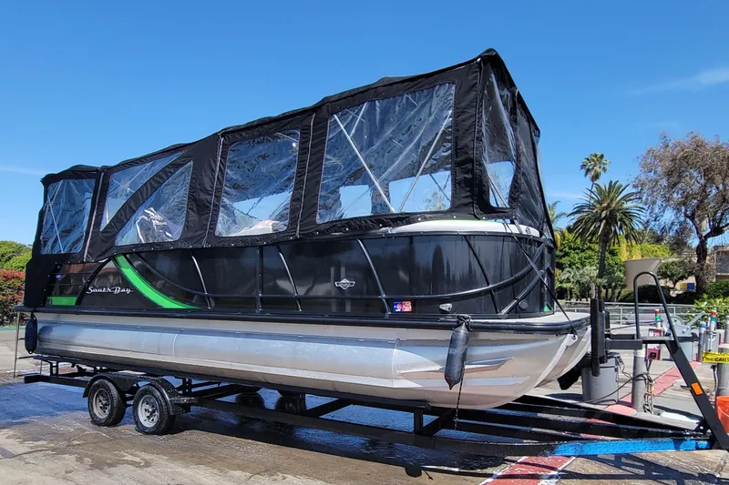 Slide: The Image of 2023 South Bay 525UL AR pontoon boat with black canopy on trailer. - 24