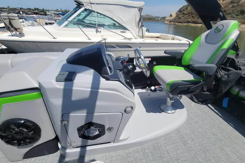 Slide: The Image of 2023 South Bay 525UL AR boat cockpit with green-accented captain's chair and control panel. - 4